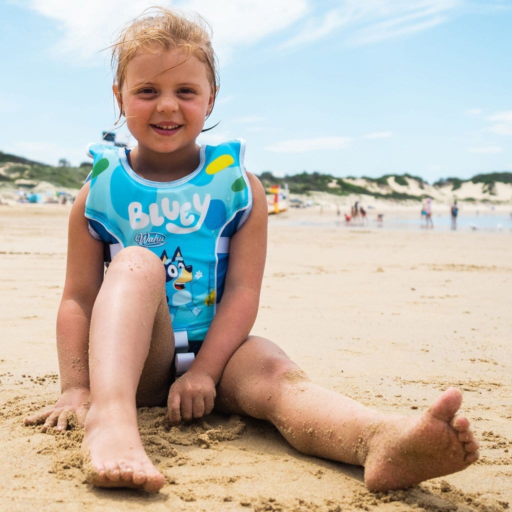 Child at beach wearing the Wahu x Bluey Swim Vest Child Small 15-25kg