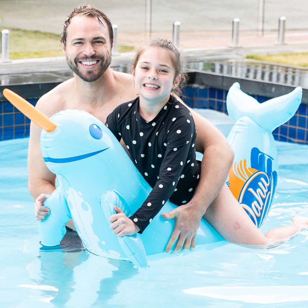 Father and Daughter in pool with the child using the Wahu Pool Pets Narwhal Racer