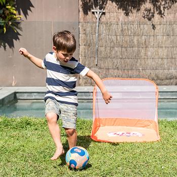young boy in backyard playing soccer with his Wahu neoprene soccer ball and wahu pop up soccer goals