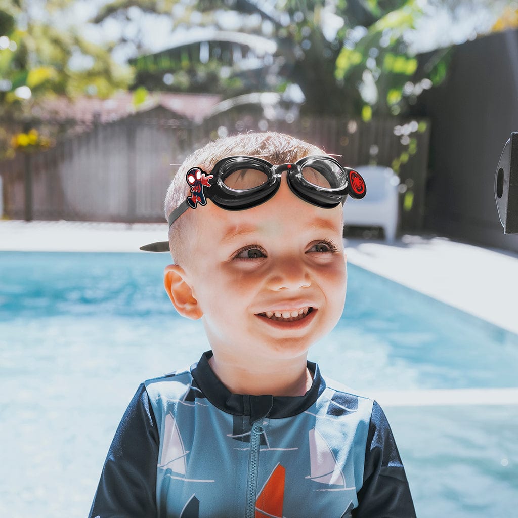 Little boy by pool wearing Wahu Spider-Man and Friends Black Swim Goggles 