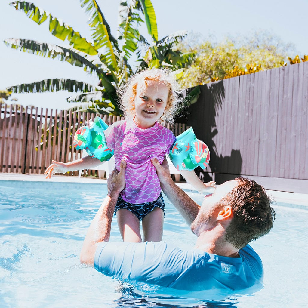 Father and daughter in pool with large Wahu The Little Mermaid armbands