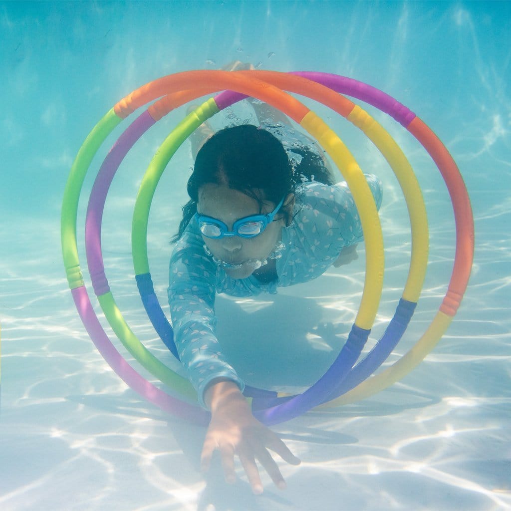 Child in pool swimming through the Wahu Pool Hoops