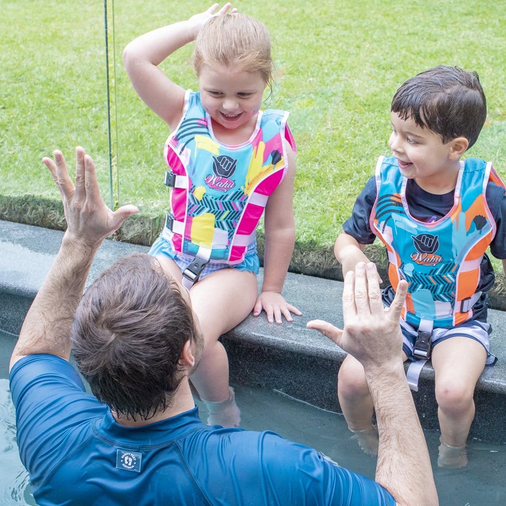 Family in pool with children wearing the Wahu Swim Vest Small 15-25kg